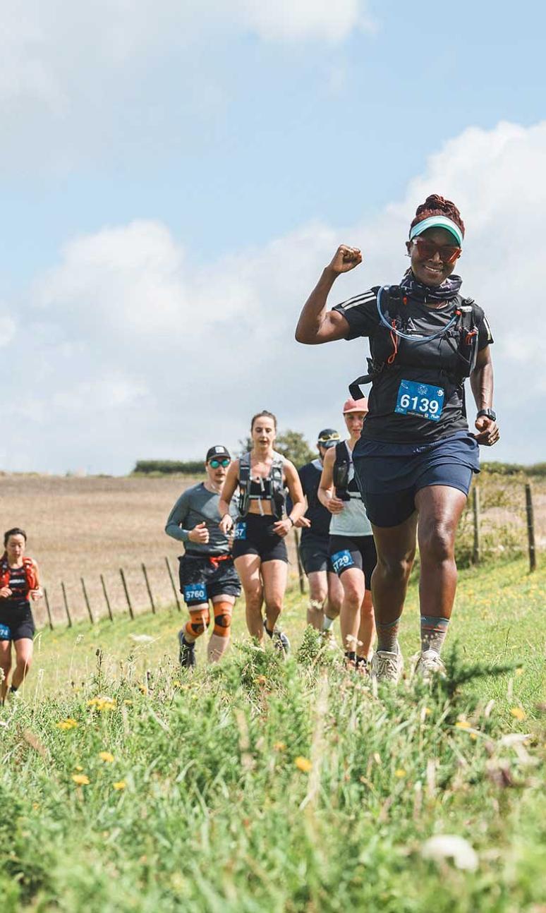A runner with her arms in the air during her Maverick race