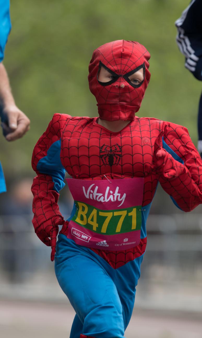 Child running dressed as spider man