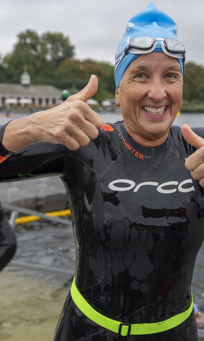 Swimmer gives a double thumbs up just out of the water