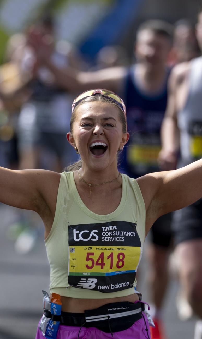 A runner cheers while on Tower Bridge 