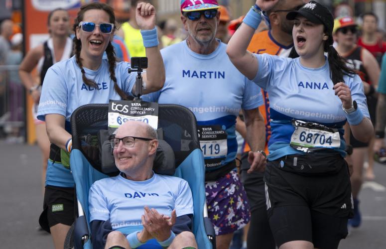 Assisted wheelchair group on the course