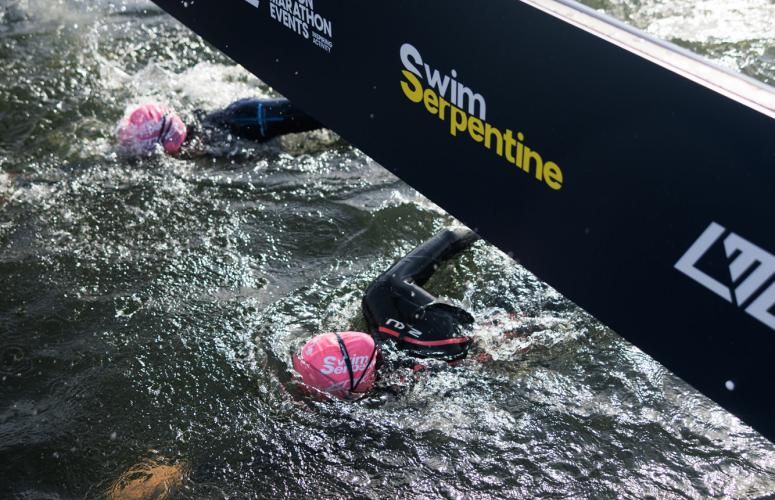 Swimmers pass under the Finish 