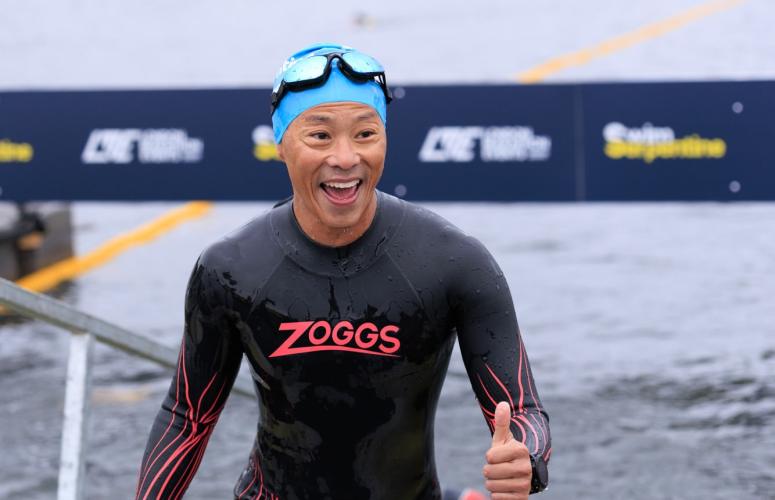 Swimmer giving a thumbs up at the finish 