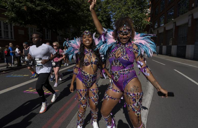 Two dancers wearing purple costumes perform on the route