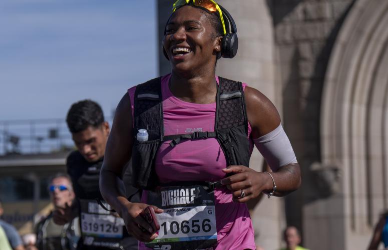 A participant smiles crossing Tower Bridge