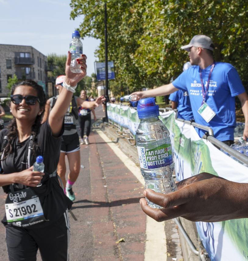 Volunteers hold out bottles of water to runners 