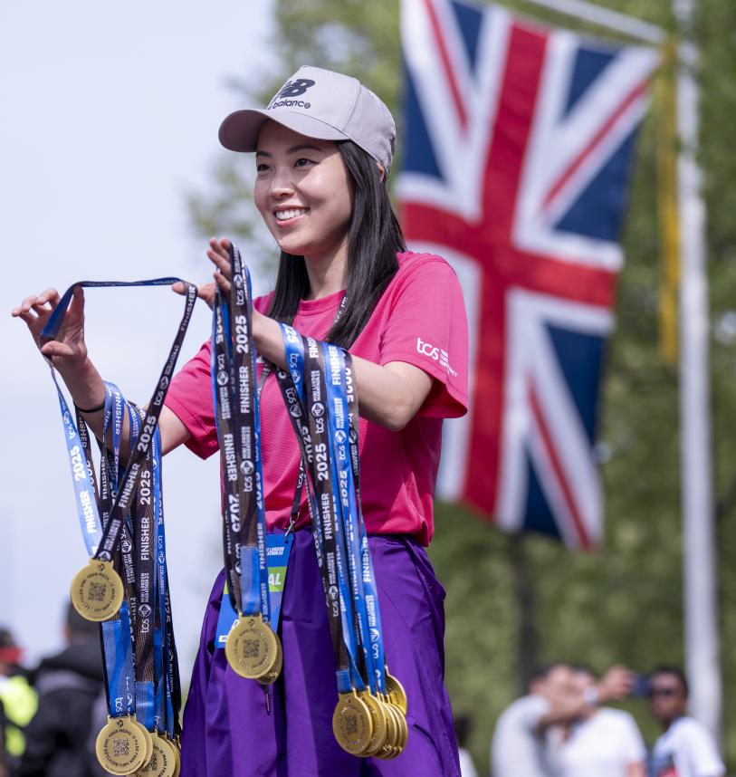Volunteer handing out medals at the Finish Line