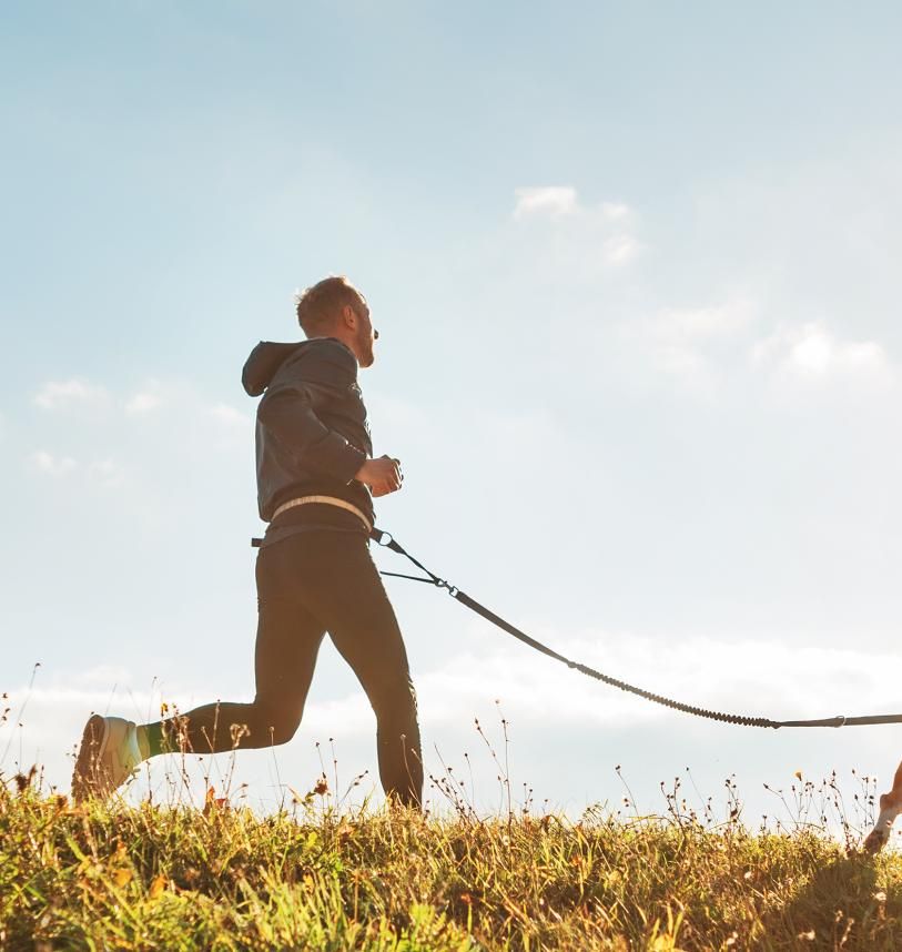 Man trail running with his dog 