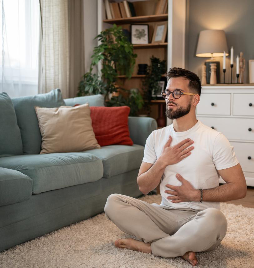Man practising breathwork in his front room