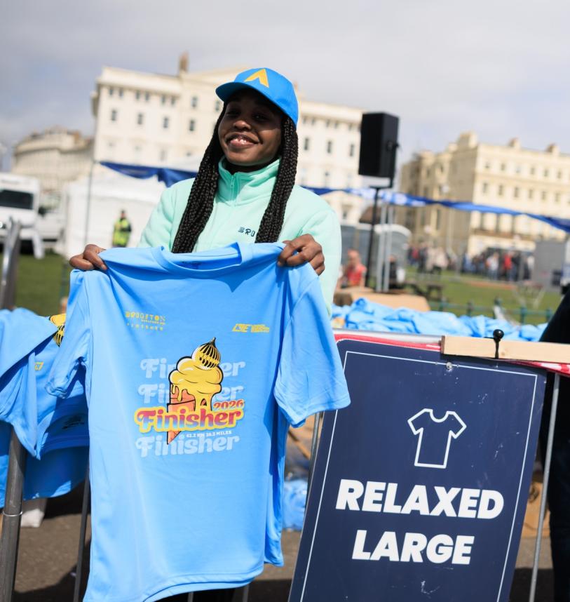 Volunteer holds up the Finisher T-Shirt