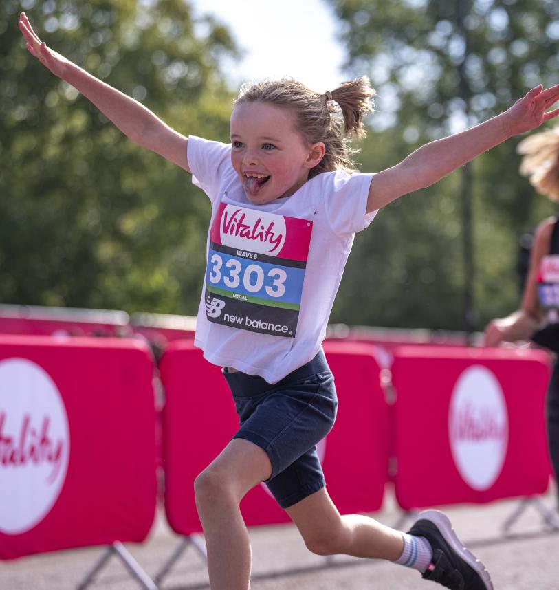 Vitality Westminster Mile runner throws their arms in the air