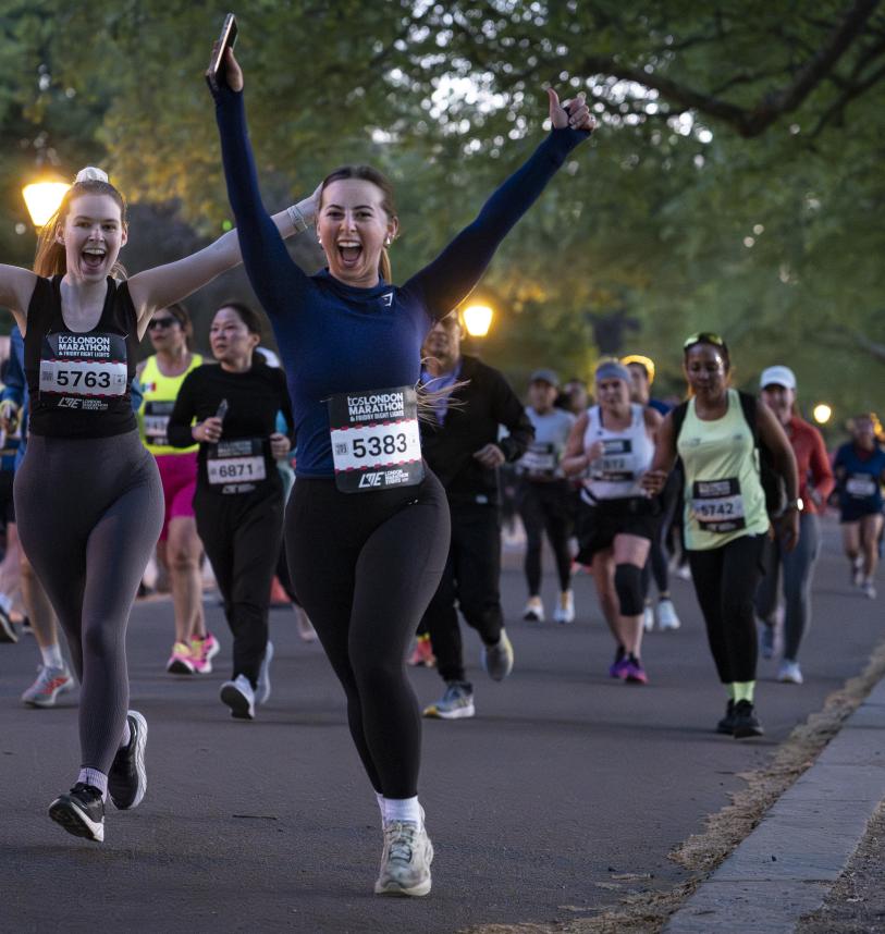Runners cheer as they pass a photographer on the course