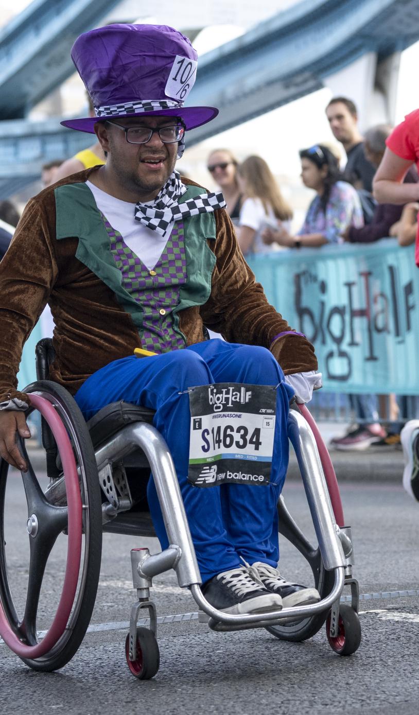 Man in a wheelchair, dressed in a Mad hatter costume participates in The Big Half