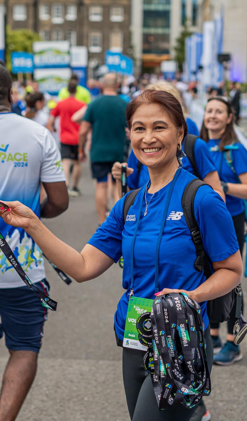 Great City Race volunteer handing out medals