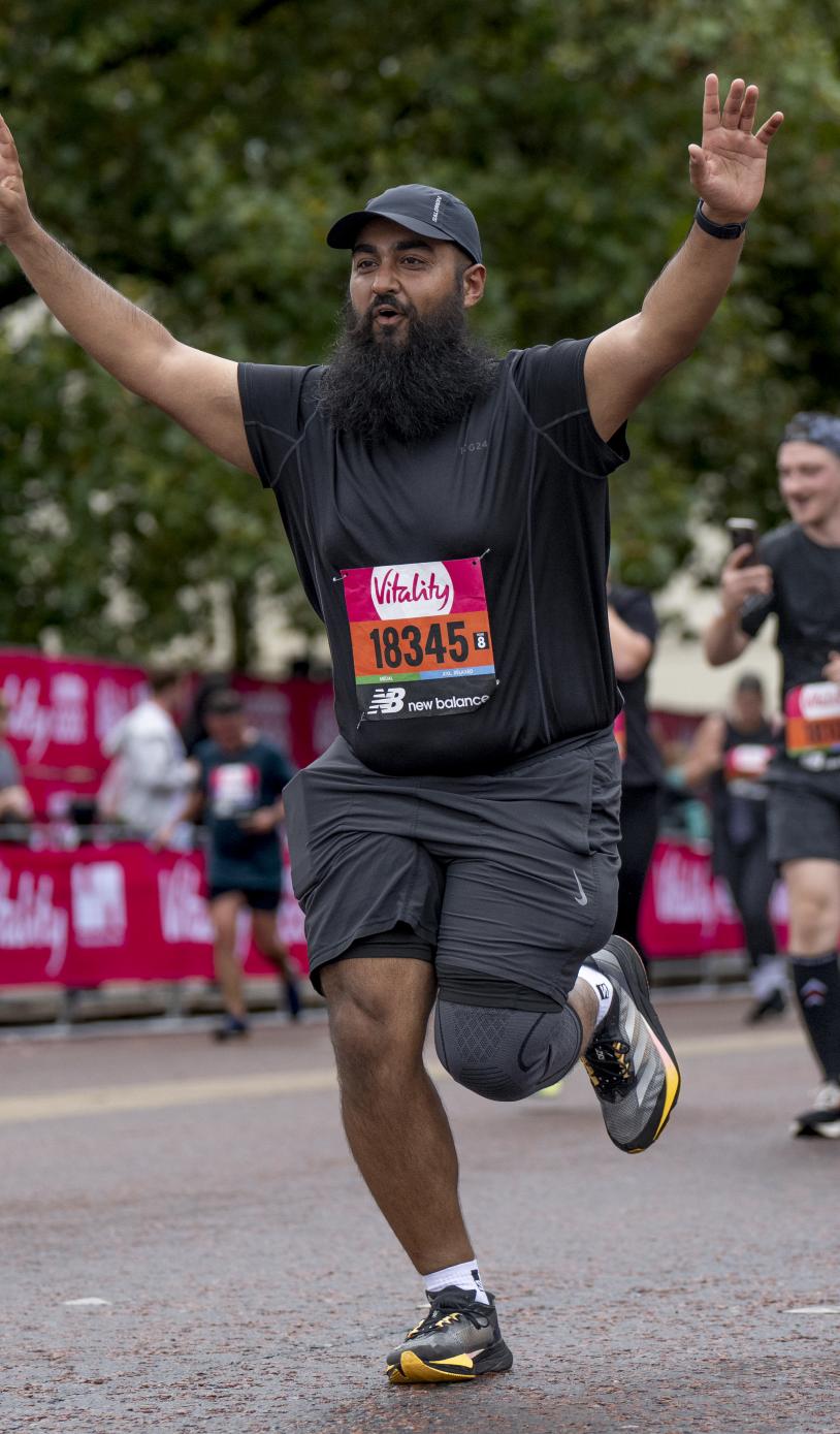 A participant celebrates as he runs along The Mall towards the Finish Line 