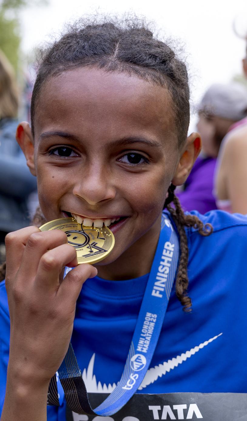 Participant biting their medal at the Finish Line