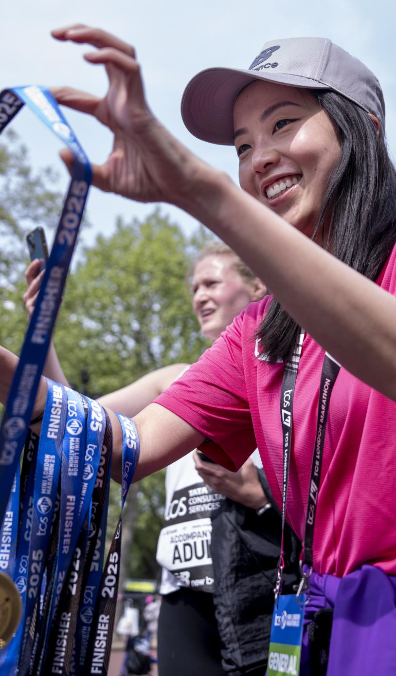 Volunteer handing out medals at the Finish Line