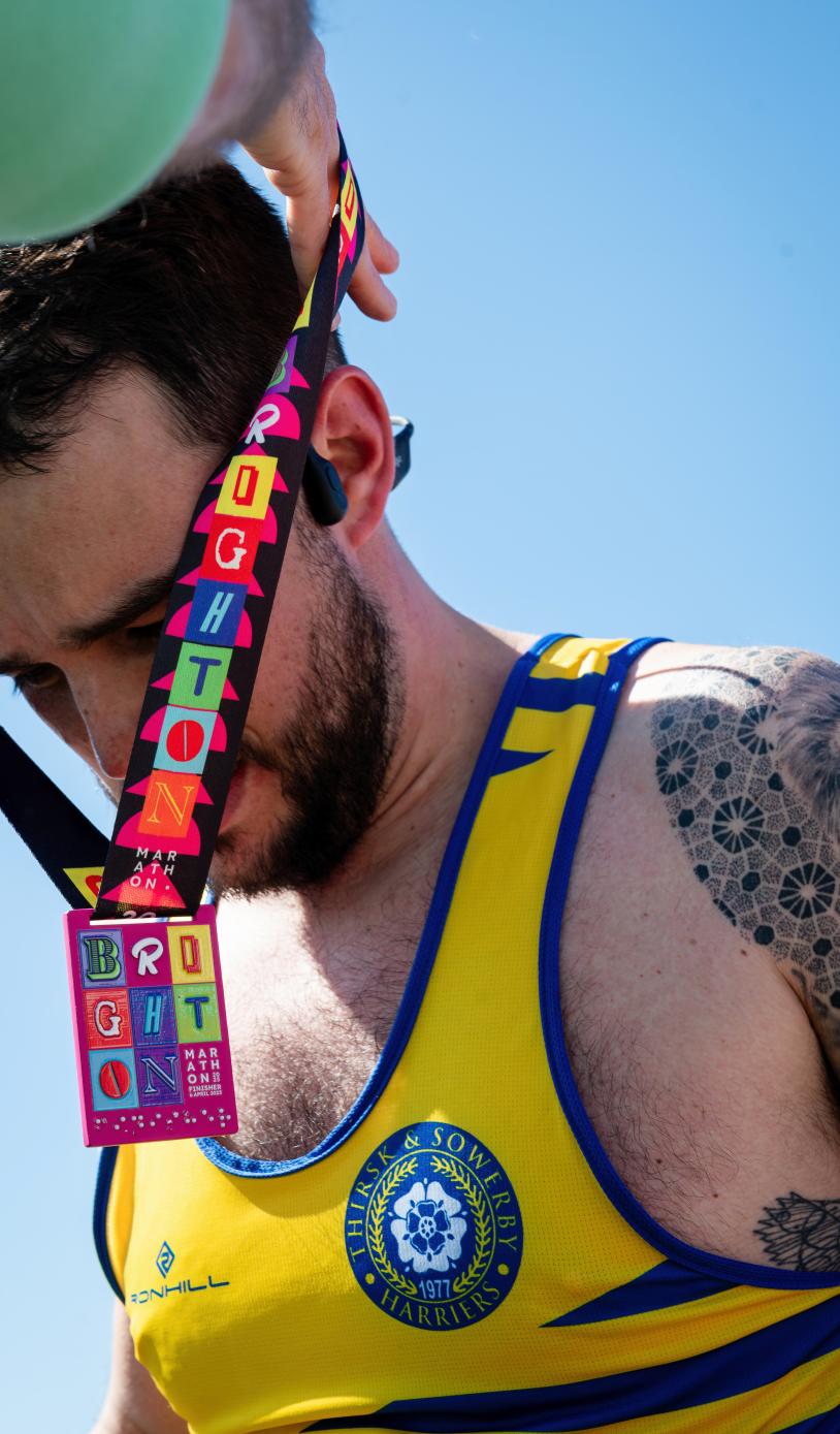 Volunteer putting a medal on a participant