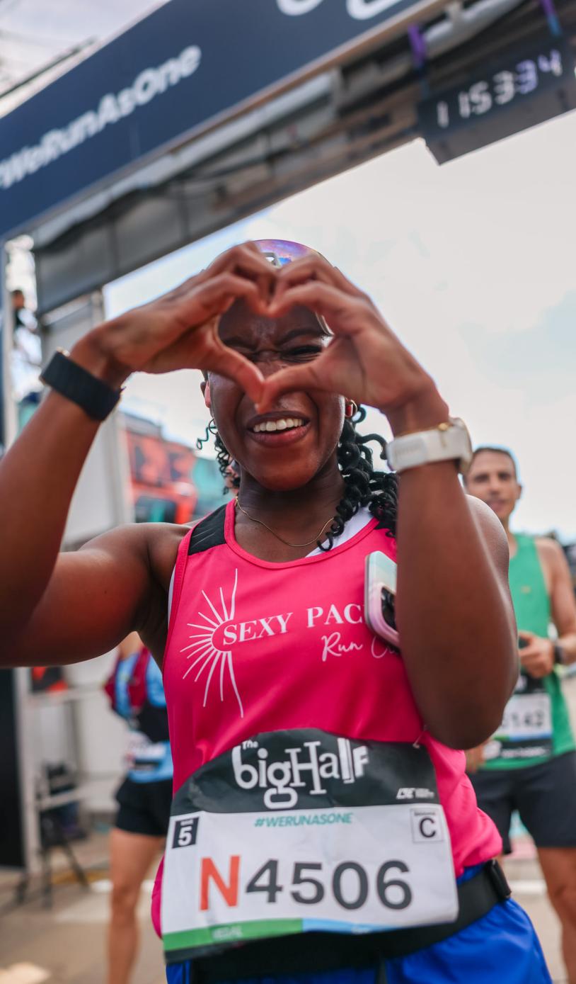 Runner making a heart with their hands at the Finish
