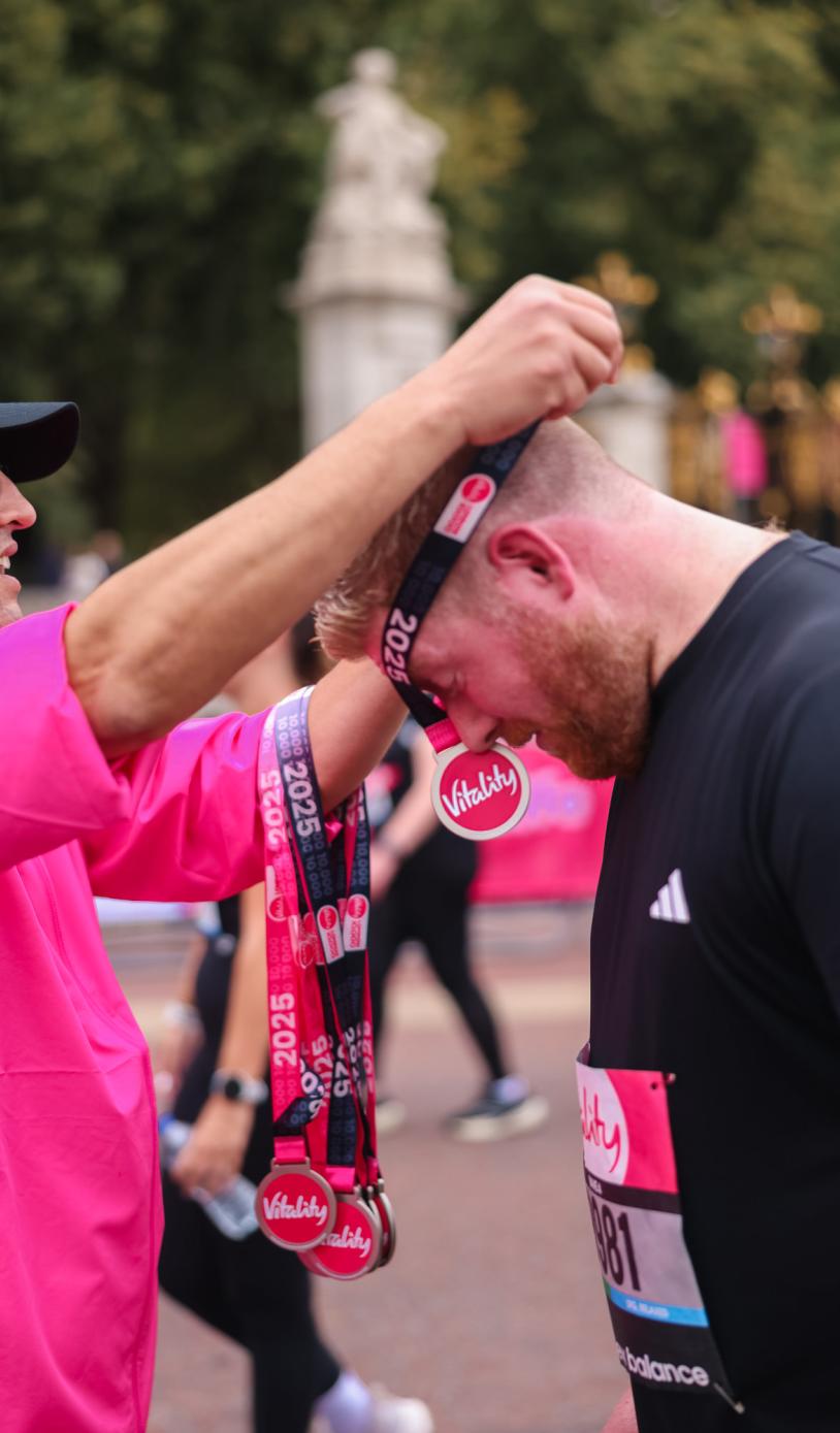 Volunteer puts a medal on a runner