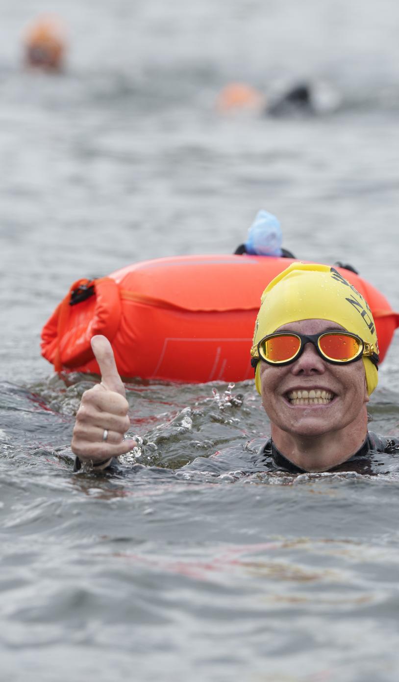 Swimmers give a thumbs up in the water