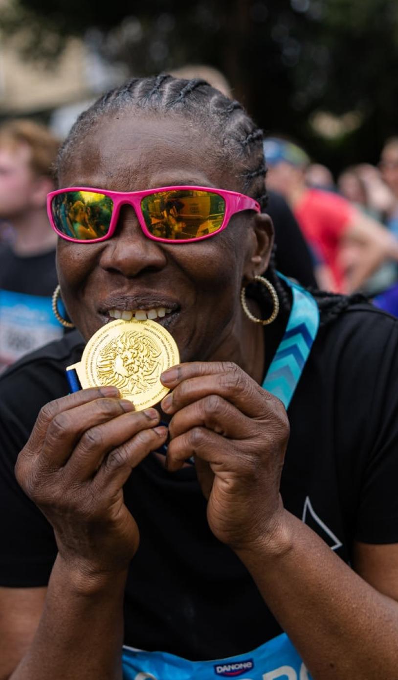 Participant biting their medal 