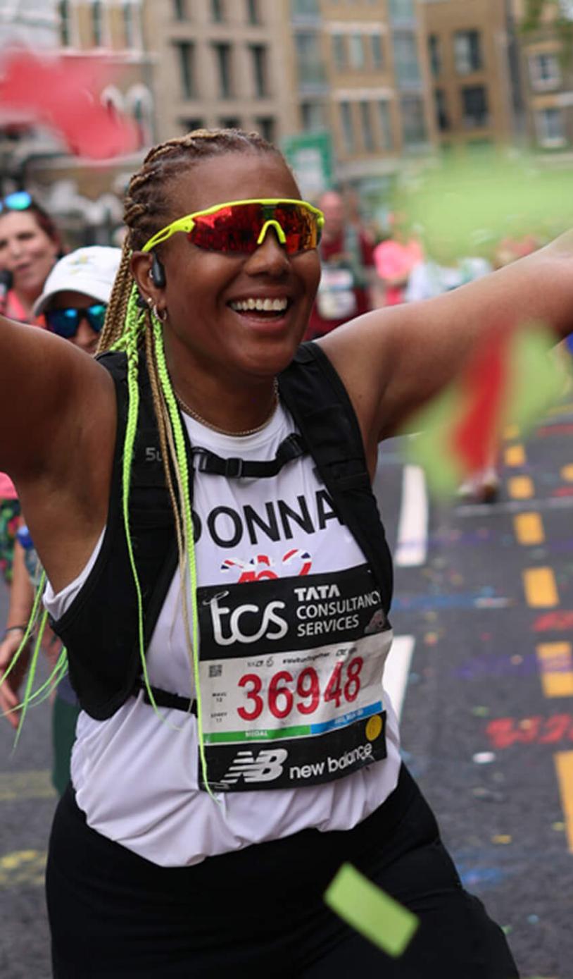A London Marathon participant celebrates amongst confetti