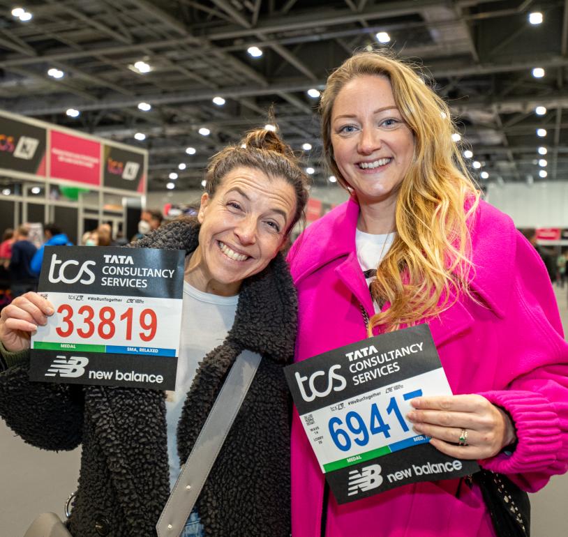 Runners pose for a photo with their bib numbers at the TCS London Marathon Running Show