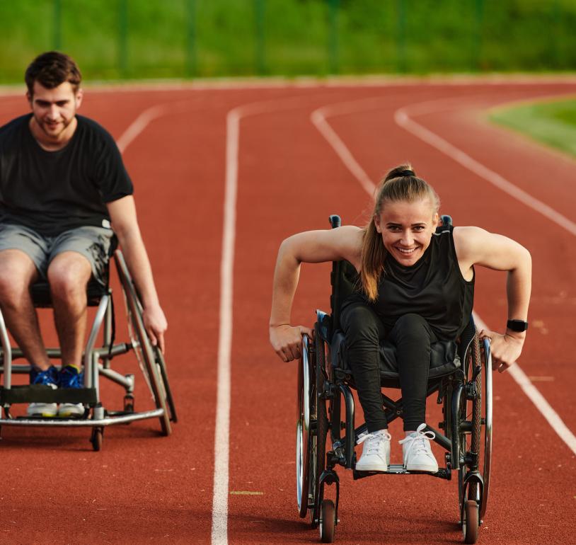 Two wheelchair users enjoying their outdoor track session