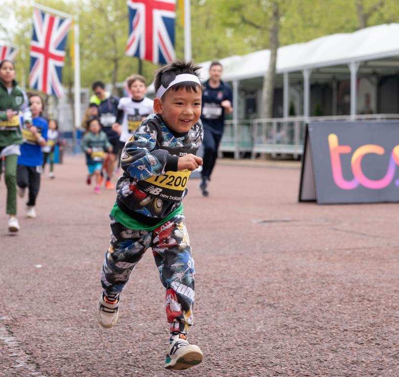 Participants run down The Mall as they make their way to the Finish Line during the TCS Mini London Marathon 