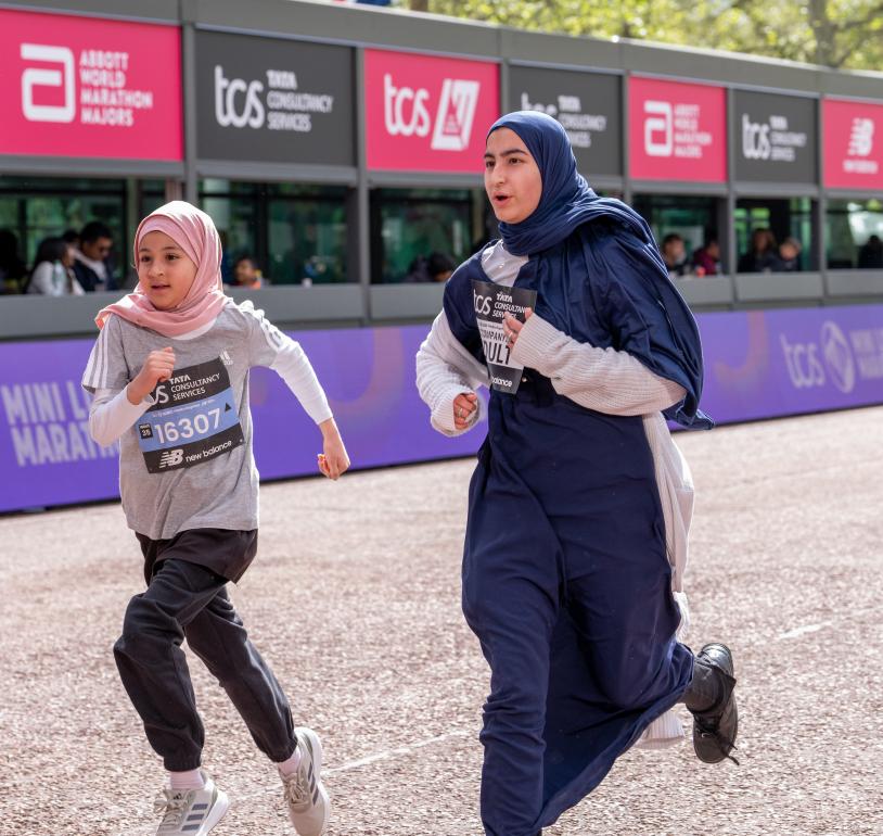 Participants run down The Mall as they make their way to the Finish Line during the TCS Mini London Marathon 