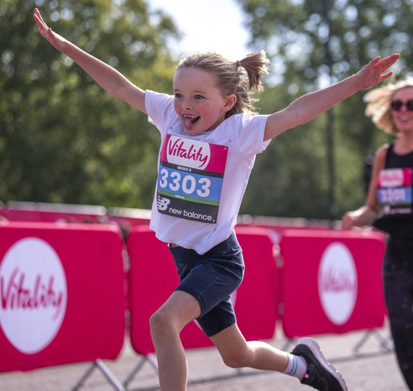 Vitality Westminster Mile runner throws their arms in the air