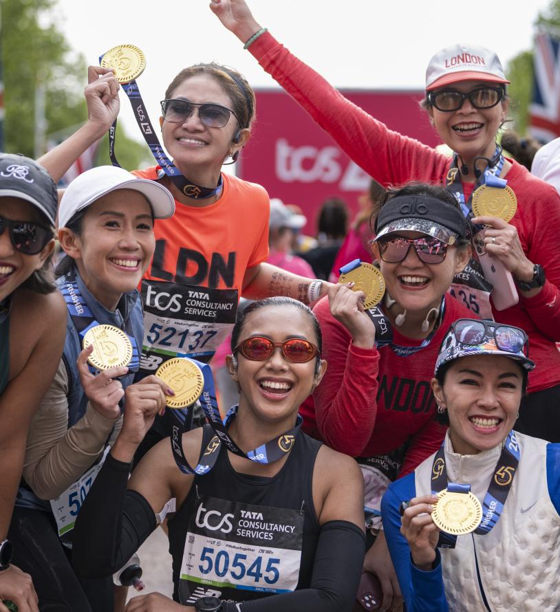 Participants pose at the Finish Line with their medals