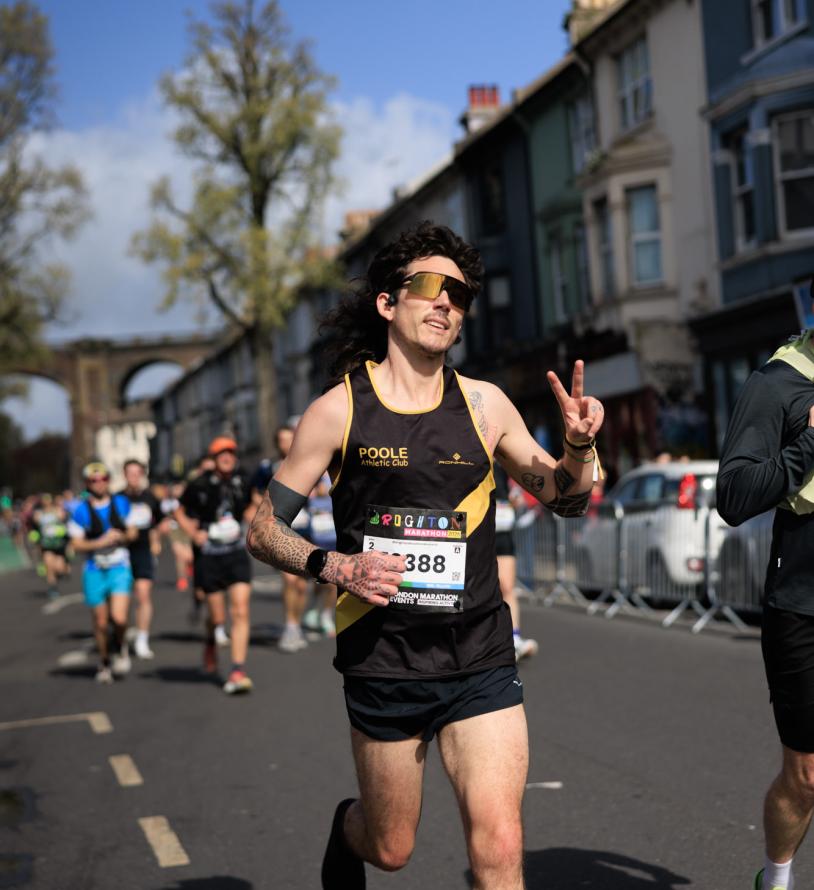 Brighton Marathon runner throwing a peace sign for the camera 